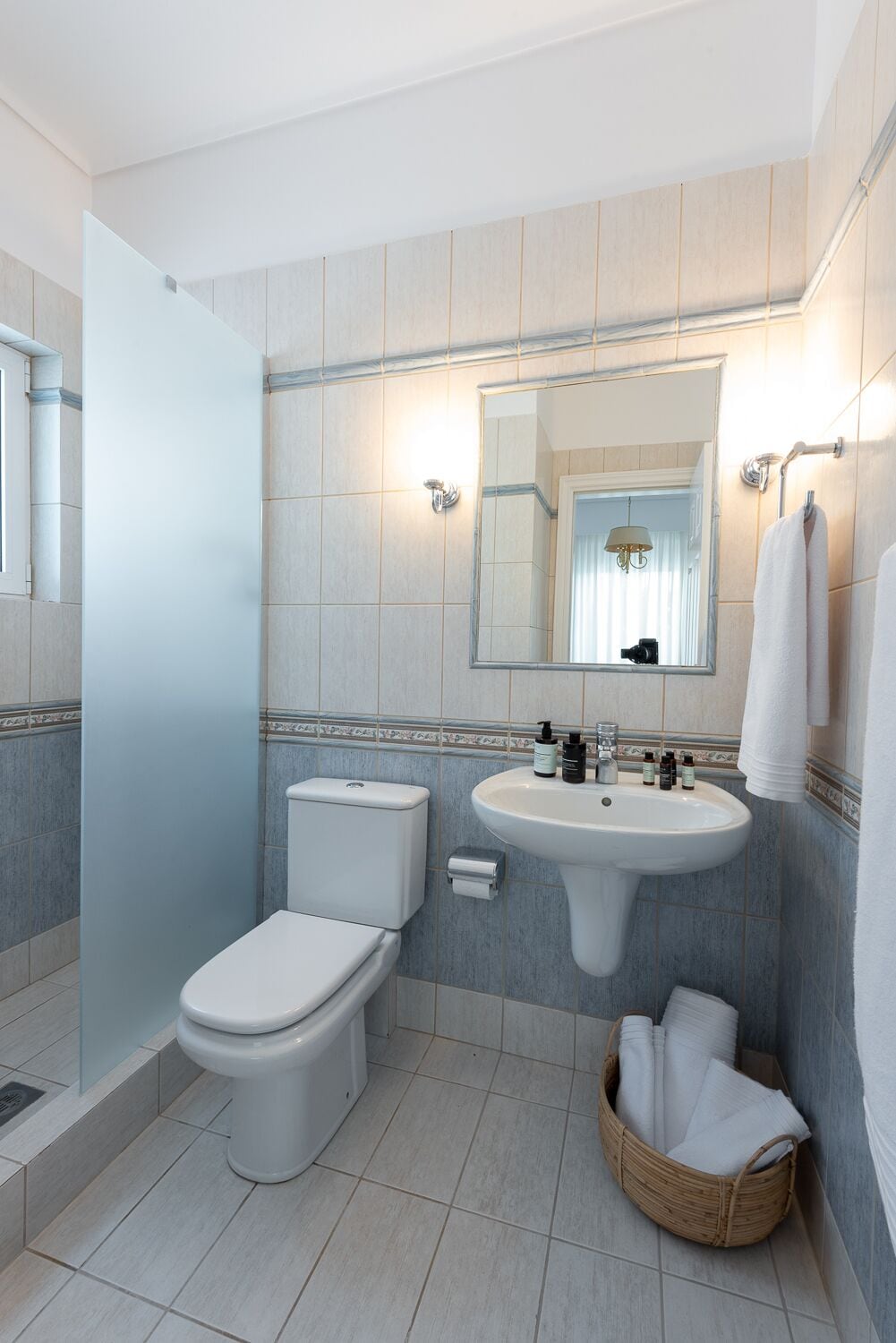 A modern bathroom with a toilet, sink, and mirror.