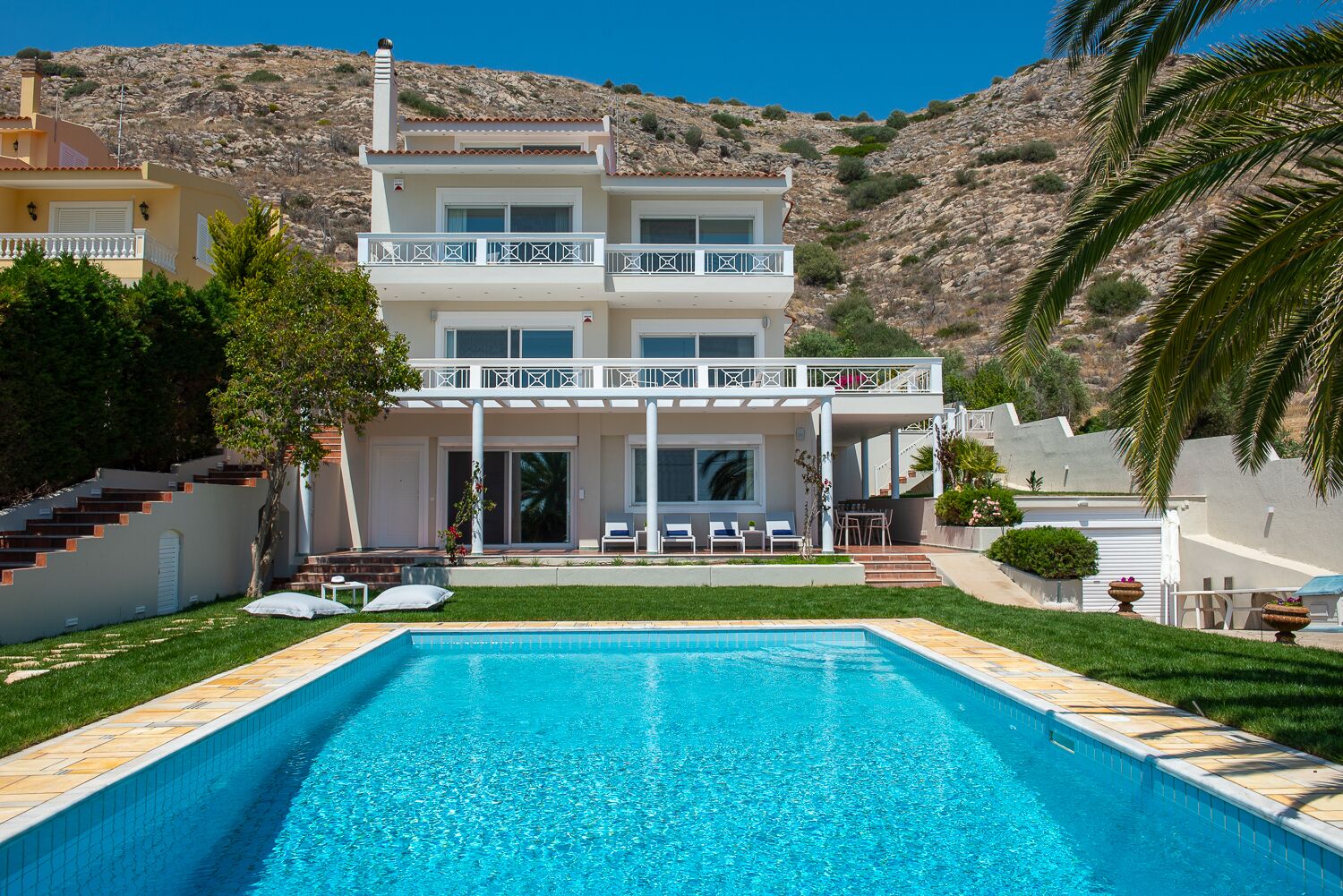 Une maison à deux étages dotée d’une piscine, d’un balcon et offrant une vue sur un paysage montagneux.