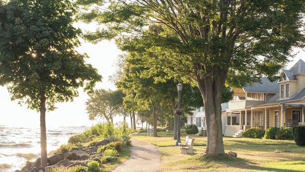 Un sentier côtier bordé d’arbres et une maison avec une véranda.