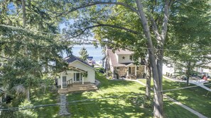 Two serene homes nestled among lush greenery and a tranquil body of water.