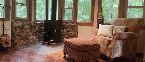 Relax in this inviting living room with a fireplace, comfortable armchair, and plush rug.