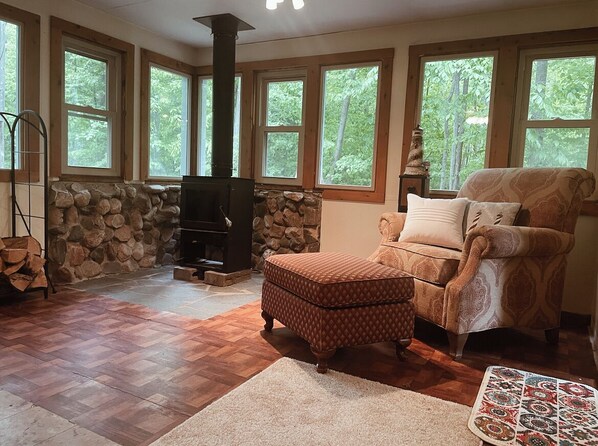 Relax in this inviting living room with a fireplace, comfortable armchair, and plush rug.