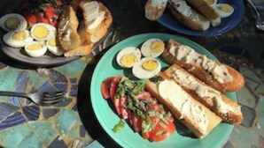 Un tavolo imbandito con diversi piatti, tra cui uova, pane e un'insalata.