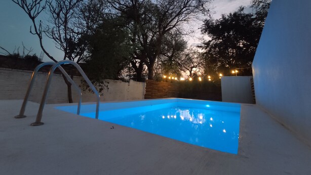 A swimming pool with a ladder, surrounded by trees and a brick wall. - Resting house with pool! near the Media Luna Spring (Ciudad Fernández)