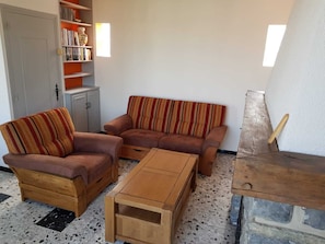 A living room with a sofa set, a coffee table, and a bookshelf.