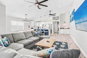 A modern living room with a grey sofa, a coffee table, and a fireplace.