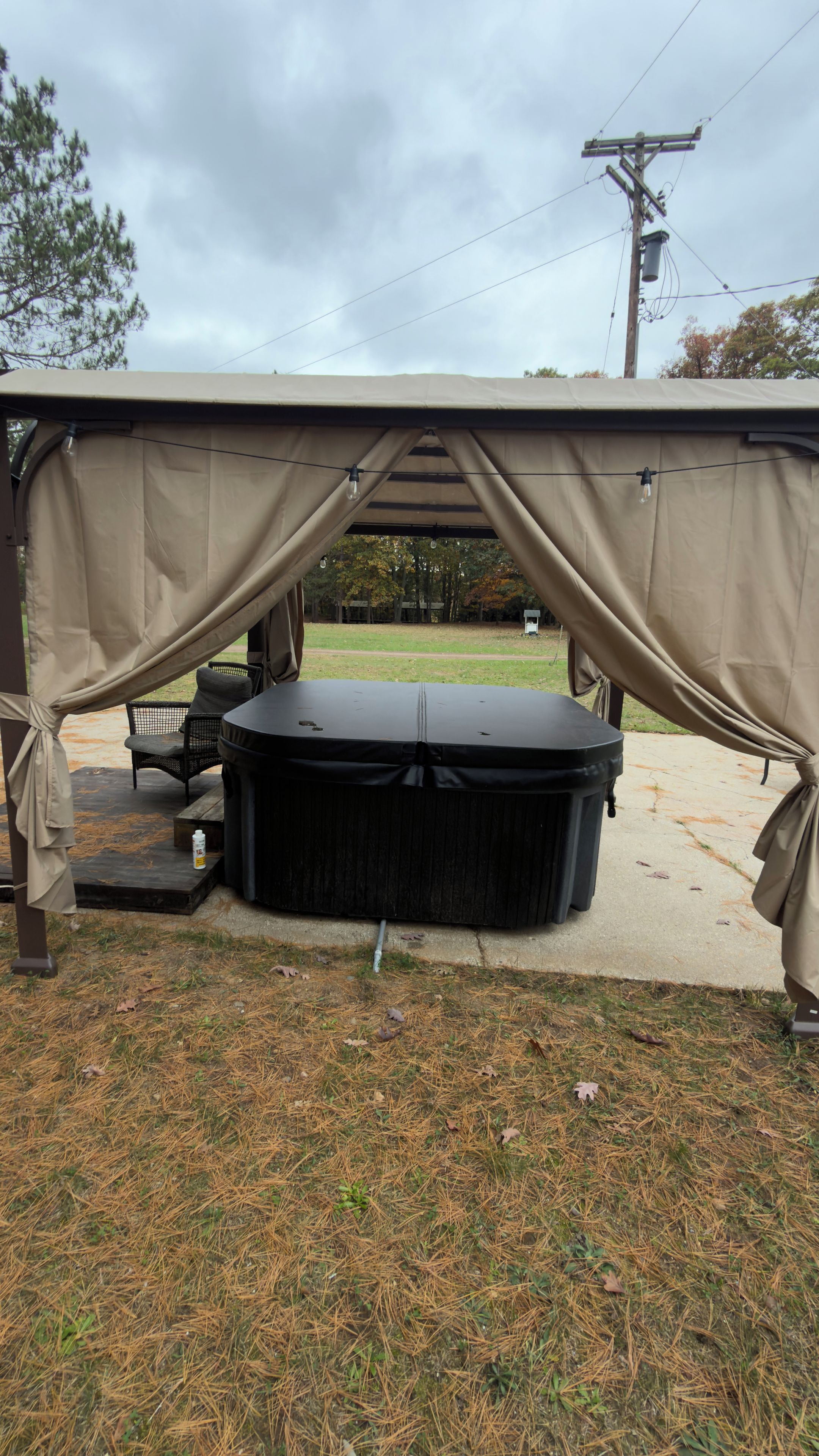 Un espace extérieur aménagé, abrité et doté d’un jacuzzi, d’une table et de chaises.