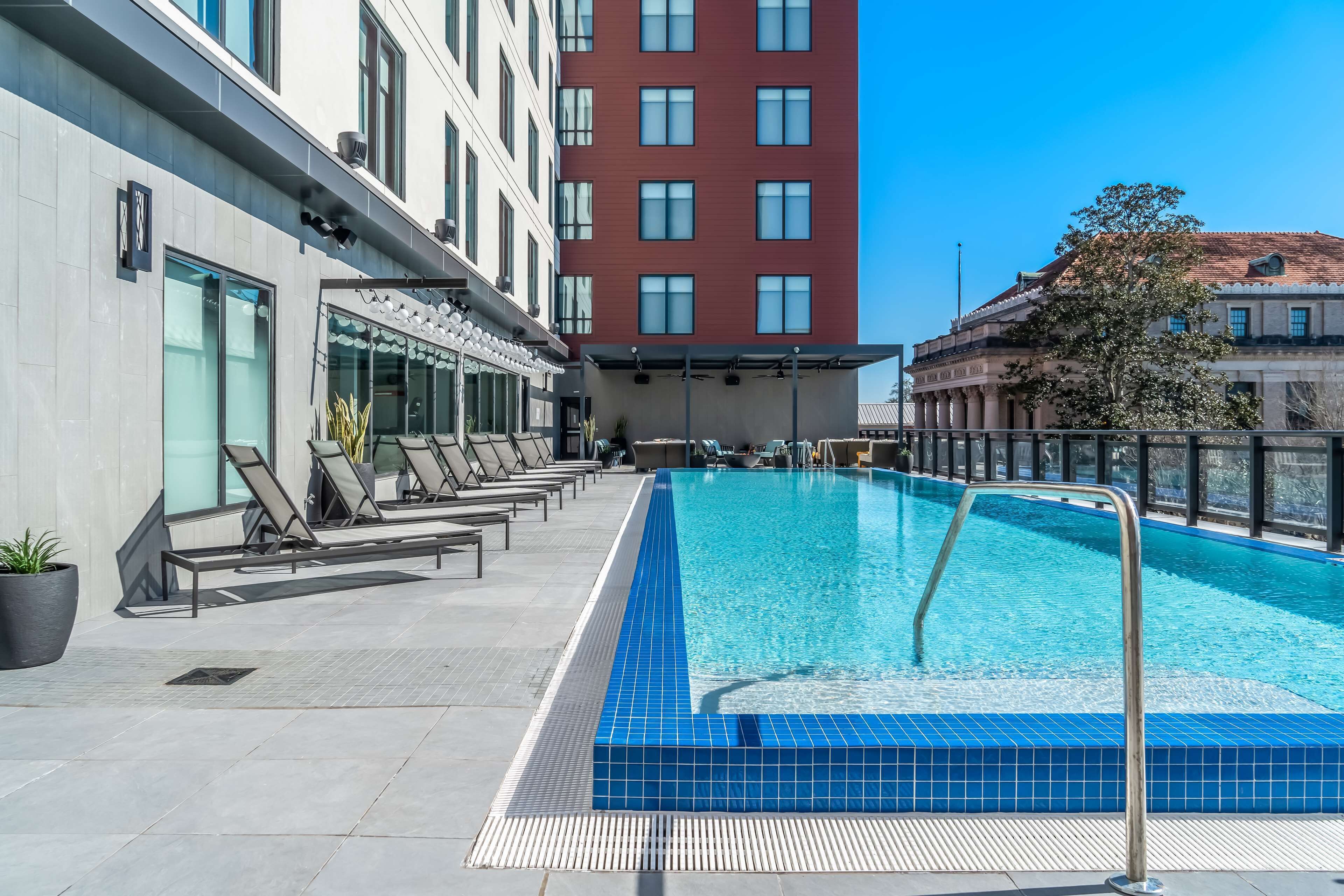 A hotel pool area with lounge chairs and a clear blue pool.