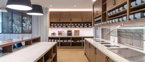 A modern kitchen with wooden cabinets, a marble countertop, and built-in appliances.