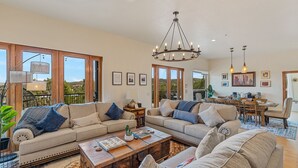 A spacious living room with large windows, a chandelier, and a dining area. - Large Villa ~ Kings & Queens ~ Chefs Kitchen ~ Views~ Hot Tub! (Sedona)