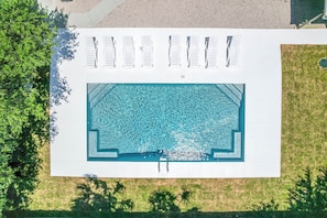 An aerial view of a swimming pool with multiple lounge chairs and a clear blue water surface. - Paradise Palms - Tropic Suite - Heated Pool! (St. Augustine)