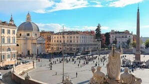 A square with a statue in the center, surrounded by historic buildings. - Ripetta Luxury Del Corso (Rome)