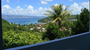 A coastal town with a view of the sea, houses, and a palm tree. - Le Turquoise (Les Trois-Îlets)