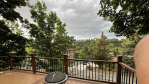 Une terrasse en bois avec une table ronde et une rambarde.