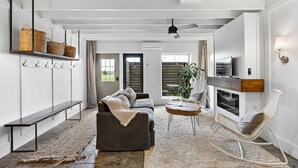 Ein modernes Wohnzimmer mit Sofa, Couchtisch, Kamin und Fernseher.