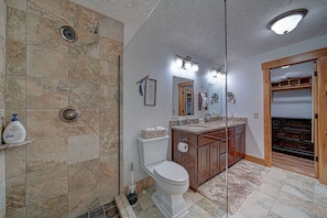 A bathroom with a shower, toilet, vanity, and a mirror. - Mountainriverretreat Star5vacations New! (Ellijay)
