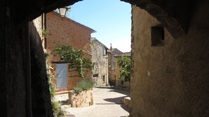 A narrow cobblestone street with stone buildings, a visible door, and a small window. - Villa Lou Coulabio - Stay in Provence with Private Pool and Panoramic View (Tourtour)