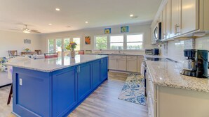 A spacious kitchen with a large island, modern appliances, and ample natural light from large windows.