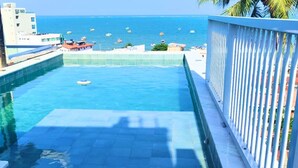 Una piscina con vista al mar y edificios al fondo.