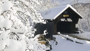 A wooden covered bridge with snow-covered trees and a clear blue sky. - Hike & Bike Stowe | 7 Min to Town | AC | Hot Tub (Stowe)