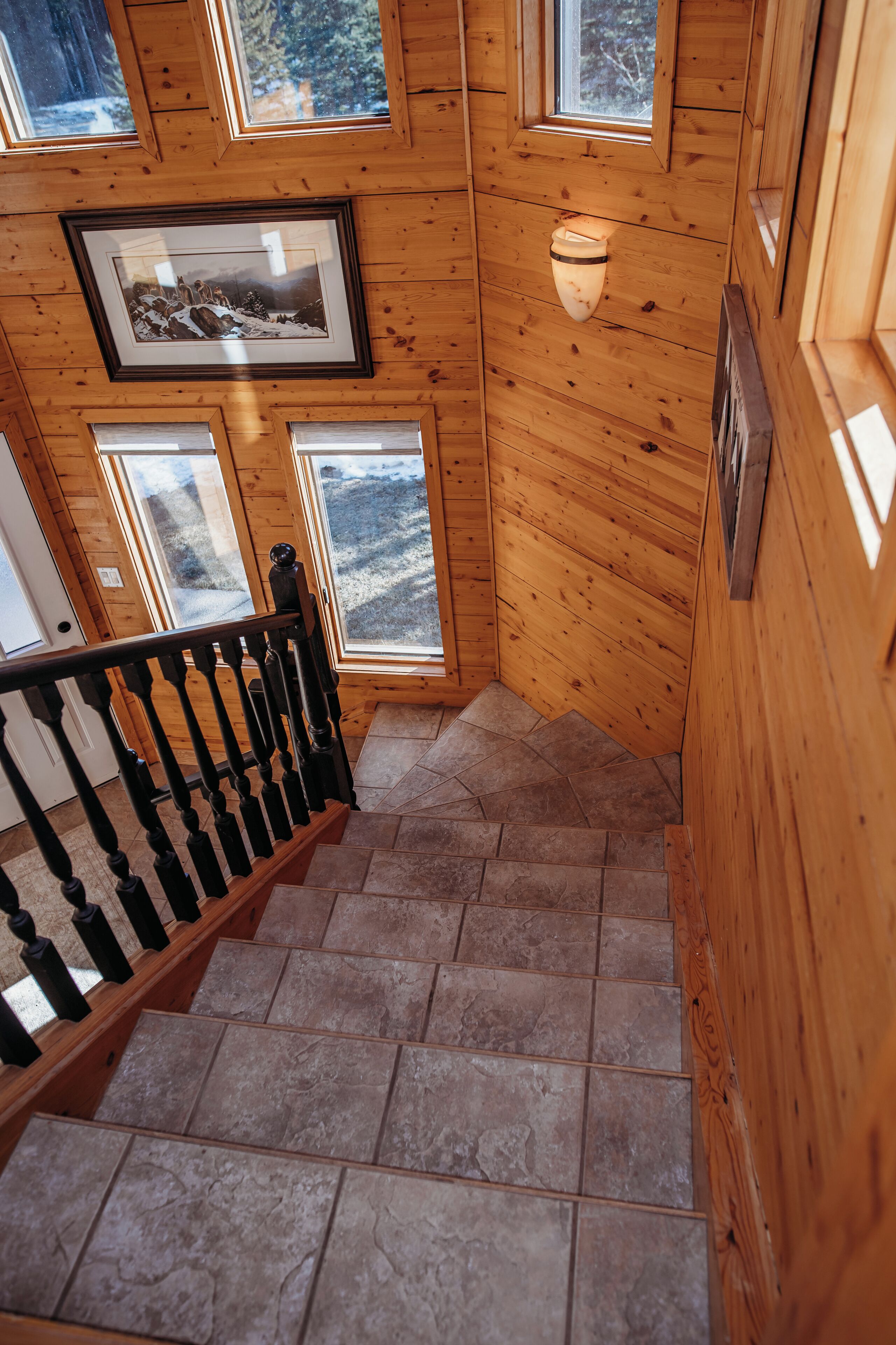 A wooden staircase with a handrail and a framed picture on the wall.