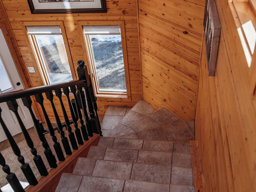 A wooden staircase with a handrail and a framed picture on the wall.