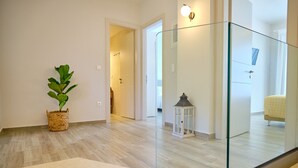 Ein modernes Interieur mit Treppe, einem Blumentopf und einem Glasgeländer.