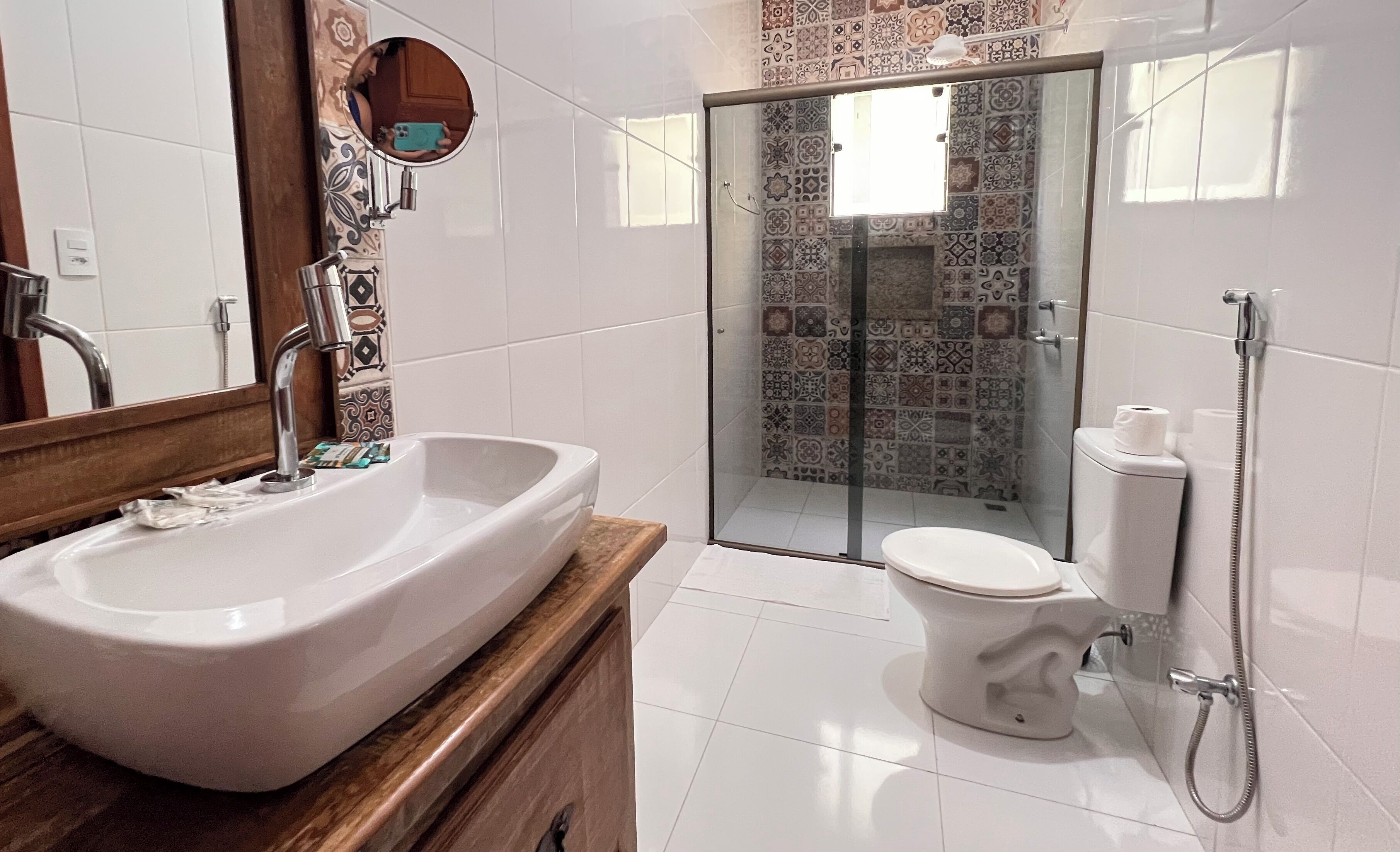 A bathroom with a large sink, toilet, and shower area.