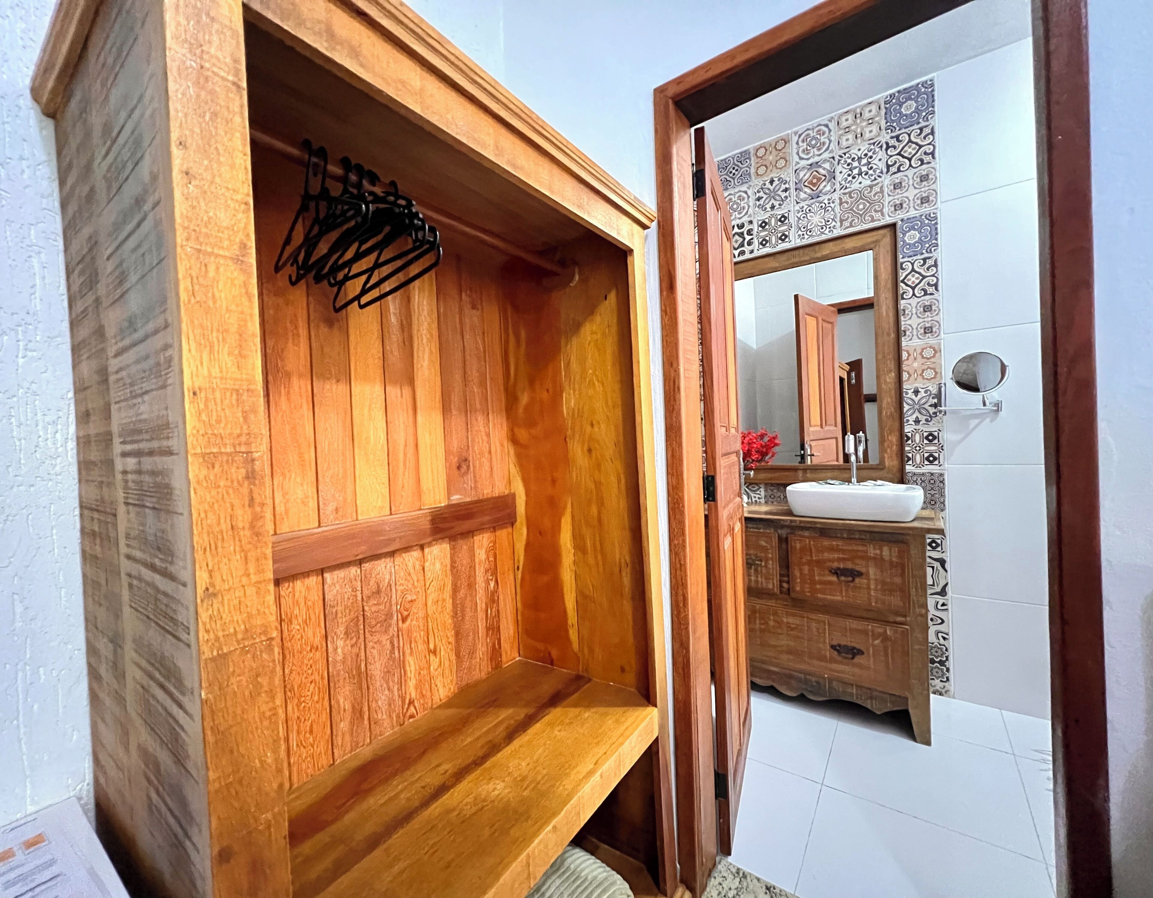 A wooden vanity with a mirror, a sink, and a towel rack in a bathroom.