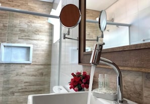 A bathroom with a modern design, including a shower with a chrome faucet, a mirror, and a wooden wall. - Pouso das Flores - Próximo a Maria Fumaça (Tiradentes)