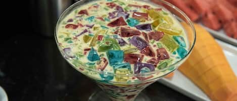 Un postre con trozos coloridos en un vaso.
