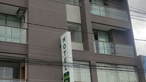 Un hotel de varios pisos con un diseño moderno, con ventanas amplias y balcones.