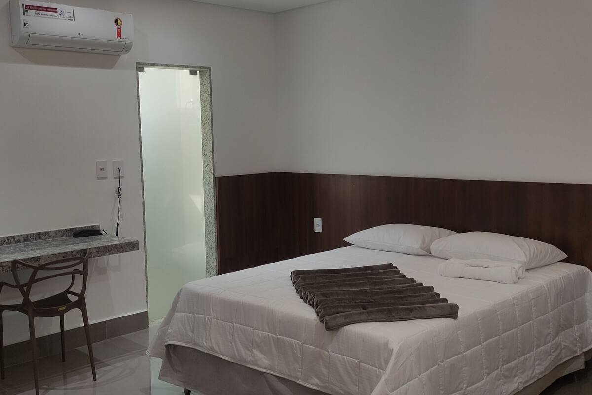 Een hotelkamer met een bed, een bureau, een stoel en een kledingkast.