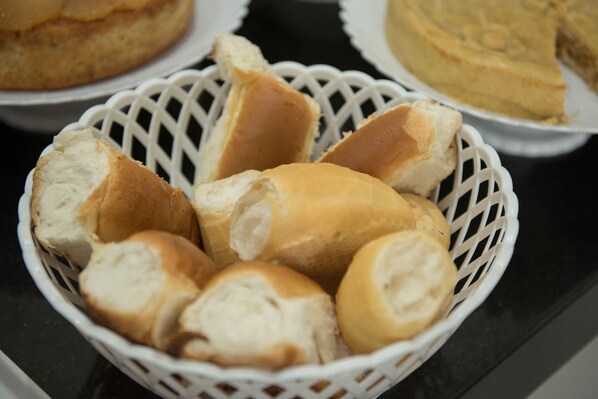 A basket filled with various types of bread rolls. - Hotel Esmeralda Verde (Teófilo Otoni)