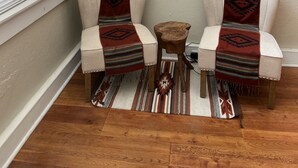 Una habitación con dos sillones, una mesita de madera y un cuadro en la pared.