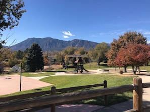 A park with a playground, benches, and a wooden fence. - Spacious 3 BDR 2.5 BA House with Hot tub, BBQ, Fire Pit, Night View, Playground (Colorado Springs)