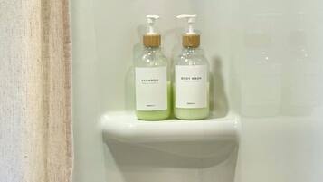 Two bottles of shampoo and body wash on a white shelf.