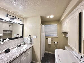 Un bagno con doppio lavabo, un grande specchio e un water.