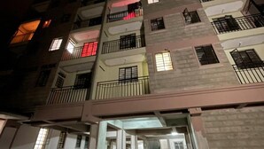 A multi-story residential building with balconies, a central staircase, and a gated entrance. - Stunning 2-bed Cozy Furnished Apartment in Nairobi (Nairobi)