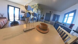 A dining area with a wooden table, a bowl, and a fish-shaped decoration. - Beachfront/2br/garden/bbq/seaview/quietretreat (Mesolongi)