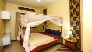 Una camera da letto con un letto a baldacchino, un comodino con una lampada e un condizionatore d'aria a muro.