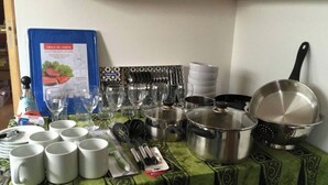 Un plan de travail de cuisine avec divers ustensiles, de la batterie de cuisine et un tableau de menu bleu.