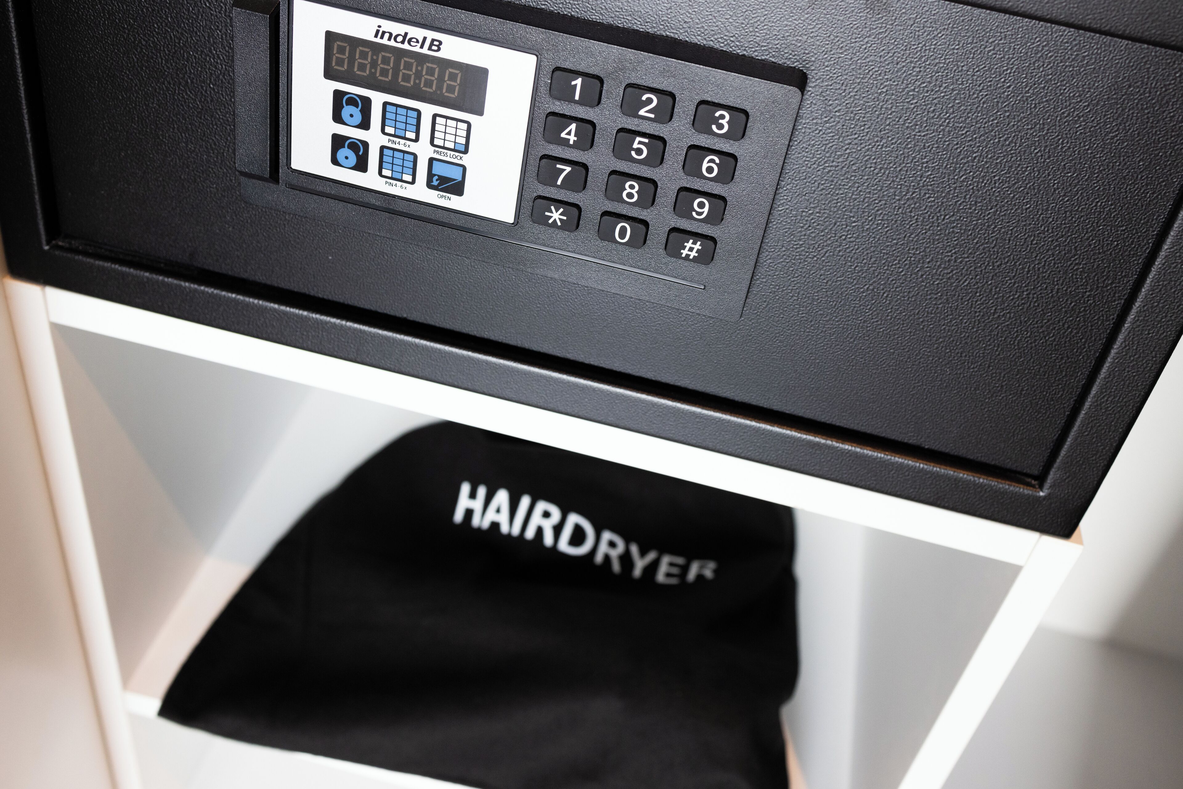 A hairdryer in a white cabinet.