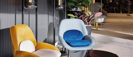 A modern interior with a yellow chair, a checkered chair, and a small table.