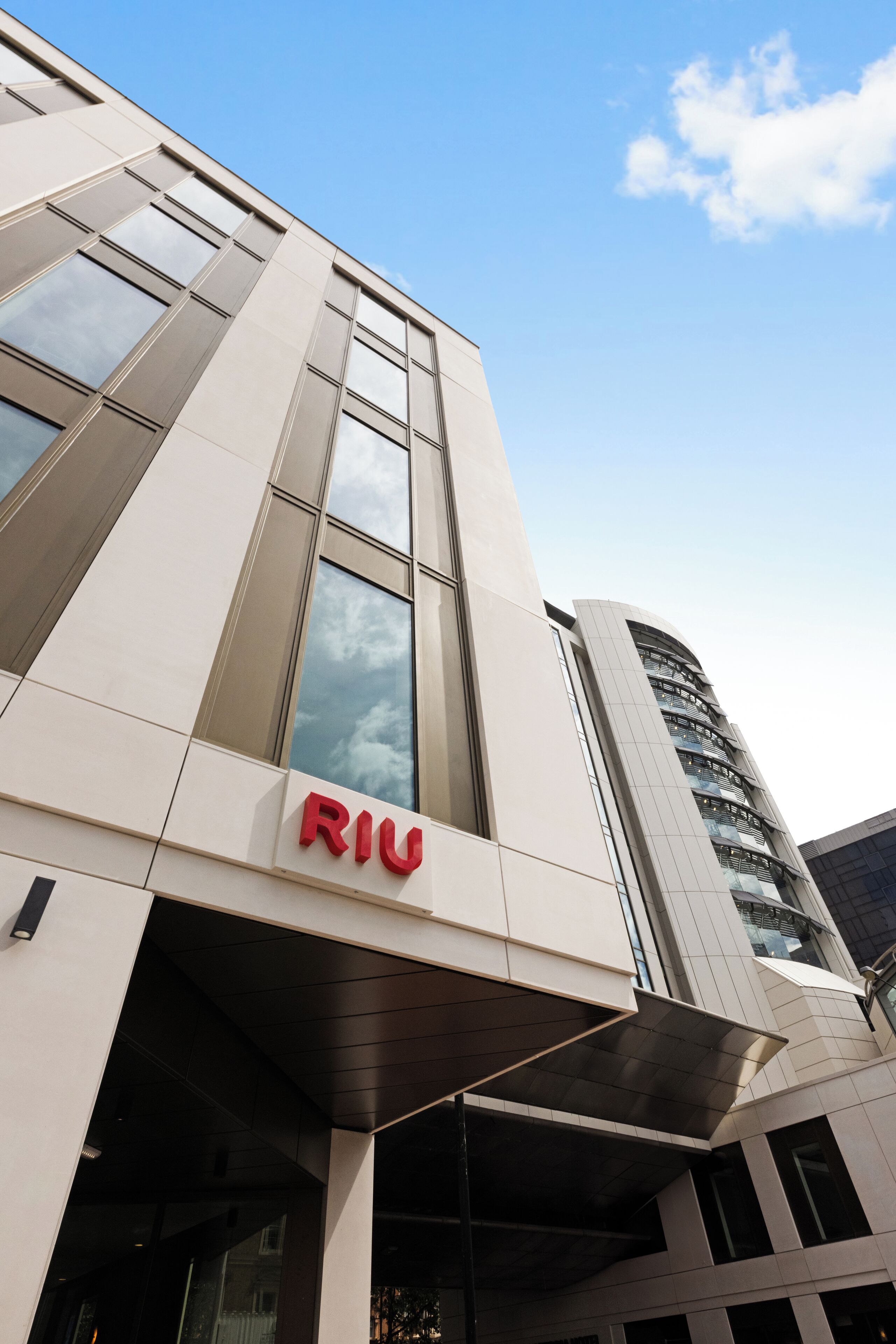 A modern building with the 'RIU' logo prominently displayed on the facade.
