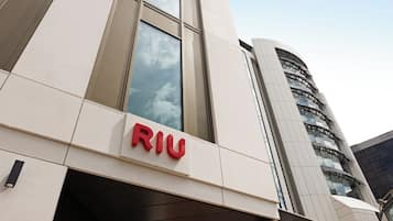 A modern building with the 'RIU' logo prominently displayed on the facade.