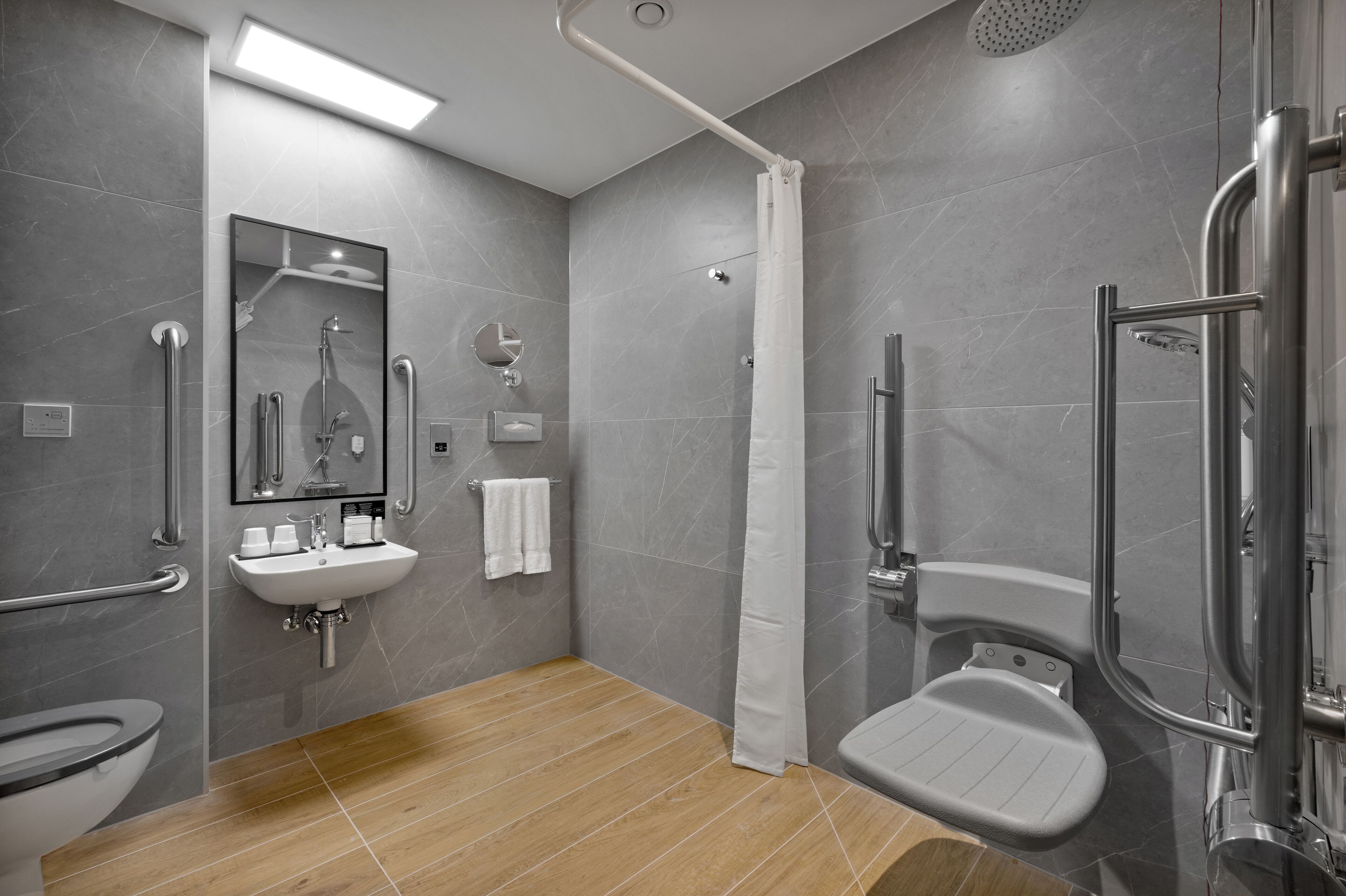 Un baño moderno con ducha, inodoro y lavabo.