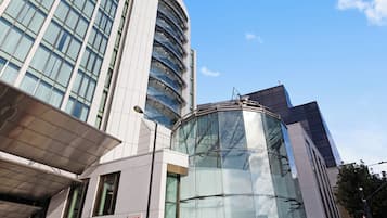 Un edificio moderno con fachada de vidrio, entrada curva y un letrero que indica que es un hotel Riu.