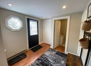 Enter a stylish room with a black door, white door, and window with blinds.