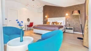 A modern bedroom with a large bed, a desk, and two chairs. - Luxury Villa Confidenza with Pool (Malinska)